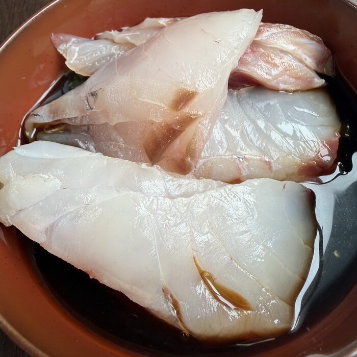 島の白身魚を醤油ダレに漬け込む